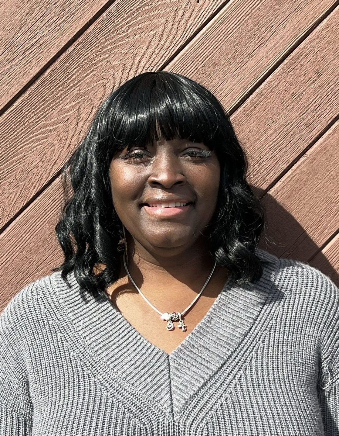 Woman in red shirt smiling at camera