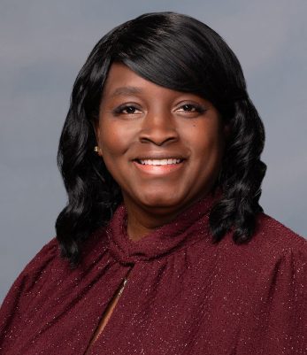 Woman in red shirt smiling at camera