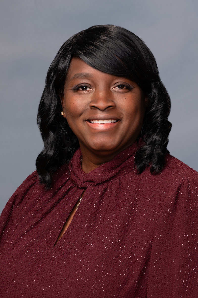 Woman in red shirt smiling at camera